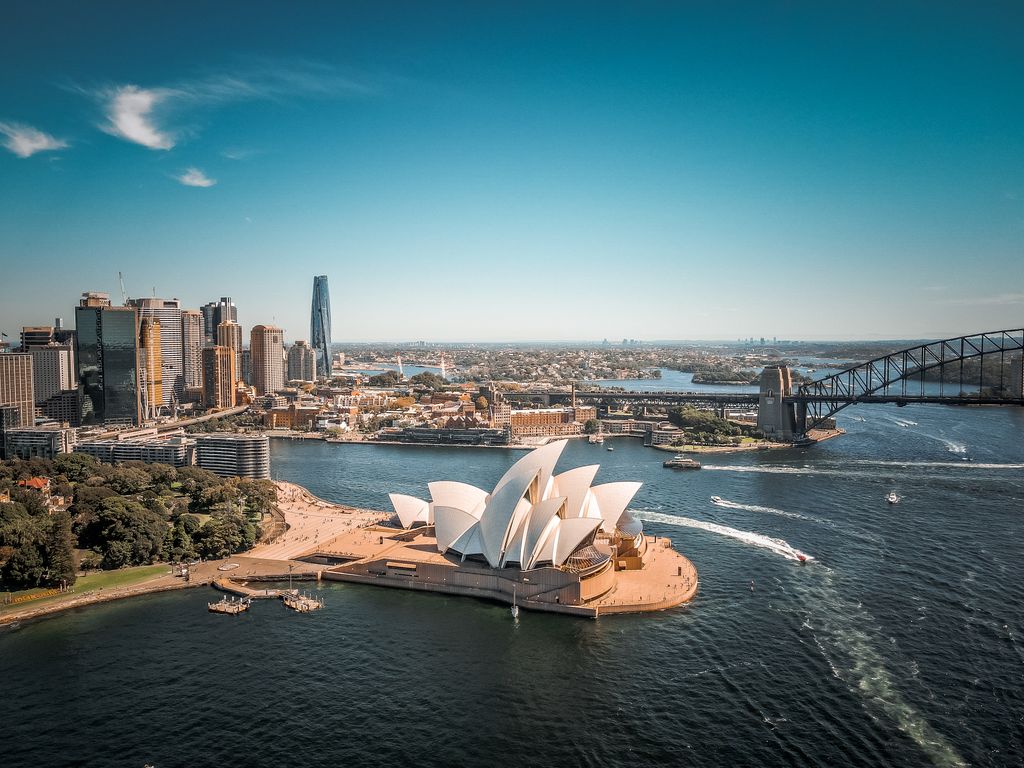 Breathtaking aerial view of Sydney Opera House with surrounding skyline and Harbor Bridge.