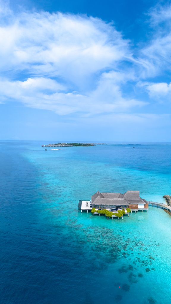 Discover serenity in this aerial view of a stunning overwater bungalow amidst the turquoise waters of Maldives islands.