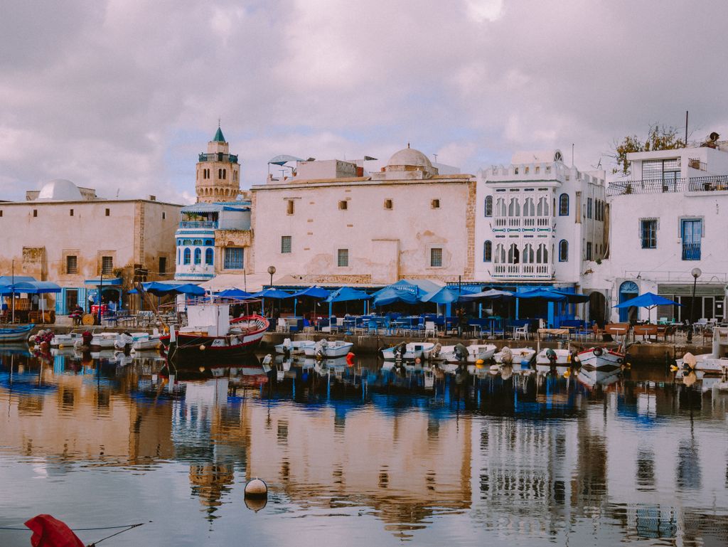 Picturesque harbor in Bizerte, Tunisia with traditional white buildings and boats.